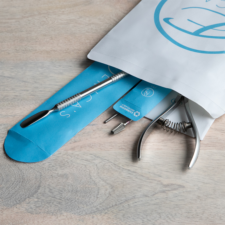 Luxury nail tools inside Erica's ATA eco friendly packaging. The packaging is blue with the words "curbside recyclable" printed on it.