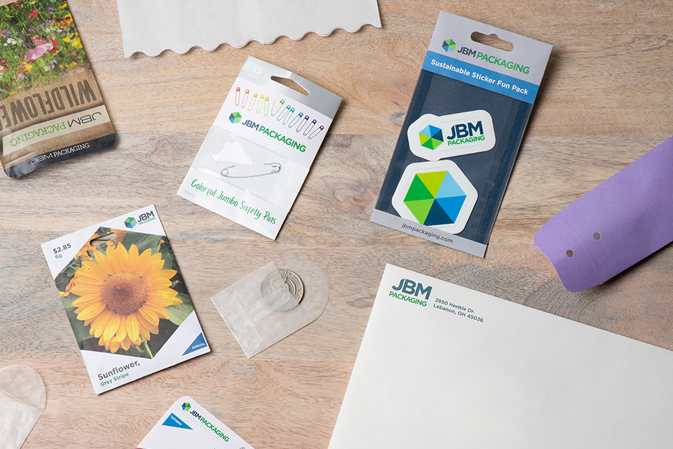 An array of different paper packaging products made by JBM including windowed packaging, glassine, seed packets, and envelopes.